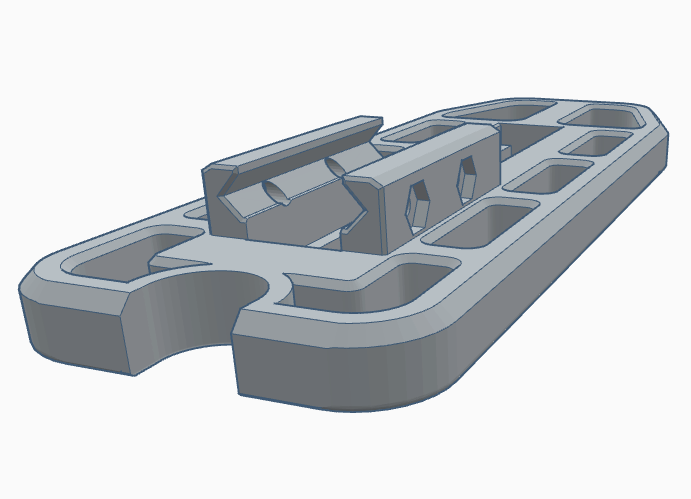 3D model of a gray plastic component with various cutouts and a central mounting feature.